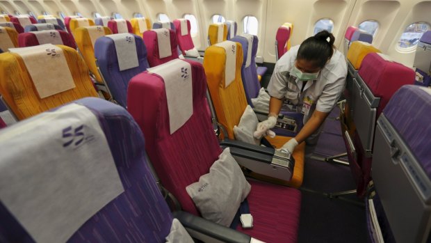 A Thai Airways worker cleans the cabin of a plane in Bangkok on Thursday in an attempt to prevent the spread of MERS infection. 
