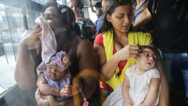 Jusikelly (right) and Inabela hold their daughters Luhandra and Graziella, both born with microcephaly on a bus ride after a Recife clinic visit.