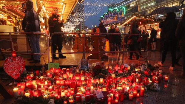 Visitors walk past a makeshift memorial at the reopened Breitscheidplatz Christmas market in Berlin after a truck killed 12 people and injured dozens on December 22.