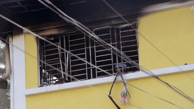 A forensic police officer investigates an Islamic religious school following a fire in Kuala Lumpur on Thursday.