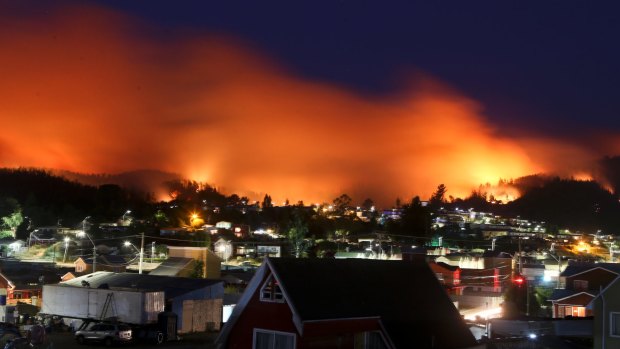 A wildfire approaches Chile's Dichato community on Monday.