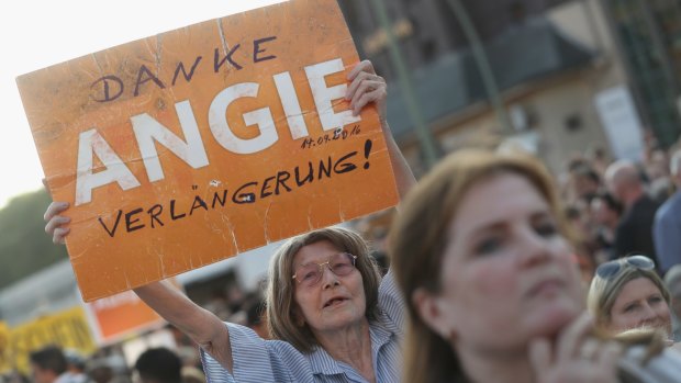A supporter of the German Christian Democrats holds up a sign that reads: "Thanks Angie, keep going!" in reference to German Chancellor Angela Merkel.