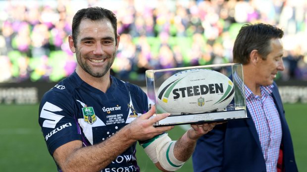 Milestone: Cam Smith holds his award after game 350, with coach Craig Bellamy in the background.