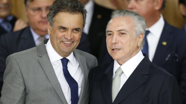 Michel Temer (right) hugs former presidential candidate Senator Aecio Neves at the signing ceremony for new government ministers. Senator Neves was narrowly defeated by Dilma Rousseff in 2014.