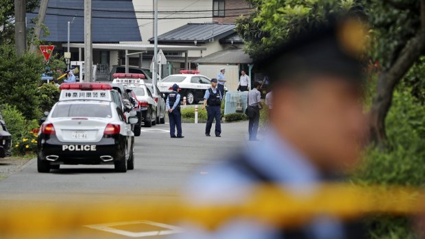 Police officers stand guard at a crossroad near the Tsukui Yamayuri-en, a facility for the handicapped, the scene of Japan's worst mass killing since WWII.