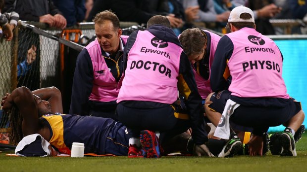 Medical staff attend to the Eagles' Nic Naitanui after he suffered a knee injury in the match against Hawthorn.
