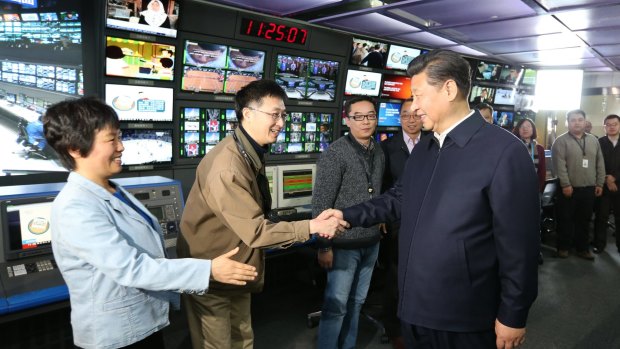 In this photo released by China's Xinhua News Agency, Chinese President Xi Jinping, right, shakes hands with staff members at the control room of China Central Television (CCTV) in Beijing in February.