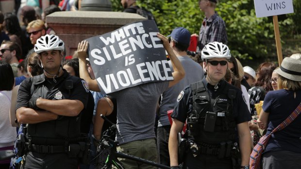 A demonstrator holds a sign that reads 'White Silence Is Violence' during an anti-racism rally in front of the US Embassy in Ottawa,  Canada last week.
