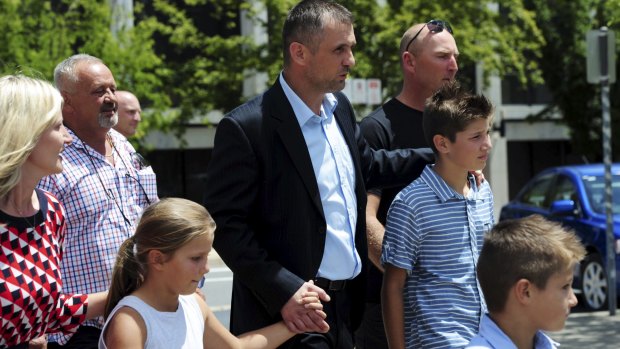 Free: Krunoslav Bonic walks from the
ACT Magistrates Court, surrounded by family and supporters.