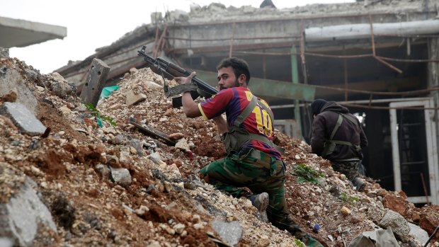 Syrian army soldiers fire their weapons during a battle with insurgents at the Ramouseh front line, east of Aleppo, Syria. 