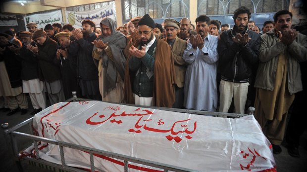 Mourners pray over the coffin of a student slain in the attack by the Pakistani Taliban.