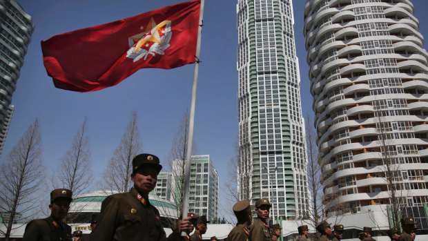 North Korean soldiers carry the Korean People's Army flag  in Pyongyang.