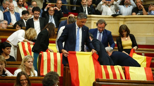 Members of the Catalan Popular Party display Spanish flags just before abandoning the session ahead of the voting during a plenary session at the Parliament of Catalonia in Barcelona.
