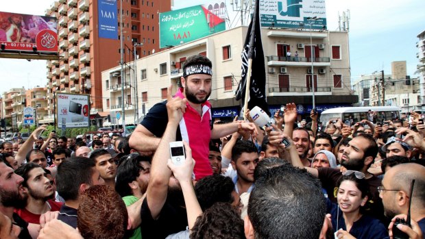 Shadi Mawlawi is borne aloft by his supporters in Tripoli, northern Lebanon, in May 2012. He is now believed to be hiding in the Ain al-Hilweh refugee camp.