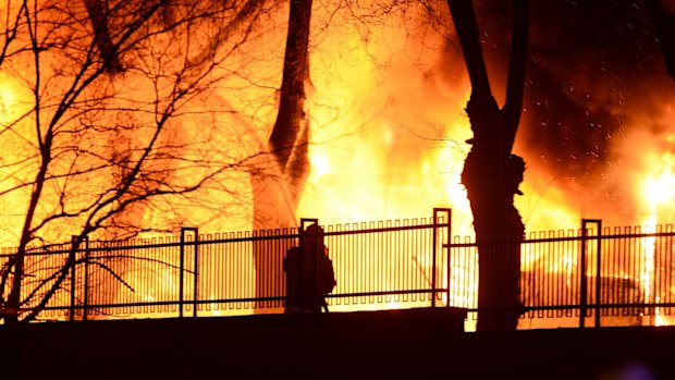 A firefighter tries to put out a fire as Turkish army buses burn after an explosion in Ankara, Turkey.  