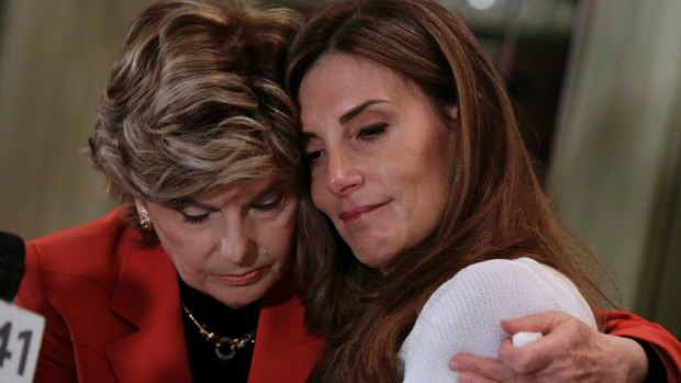 Karena Virginia, right, is hugged by lawyer Gloria Alred, during a news conference in New York.