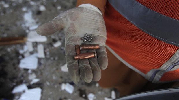 A rescue worker displays bullet casings and ball bearings collected from the site after the explosion.