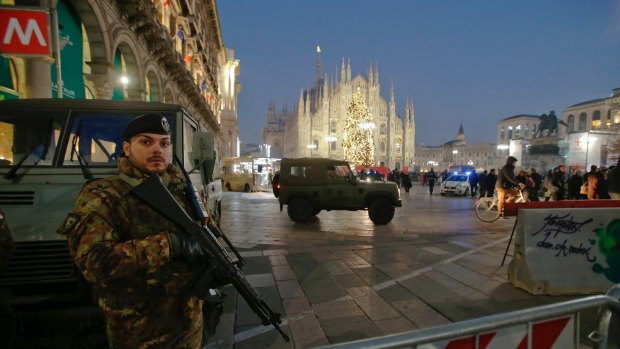Italian soldiers patrol Duomo square, with the gothic cathedral visible in background, in central Milan.