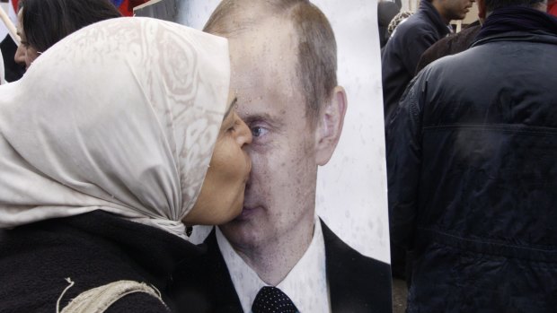 A Syrian woman kisses a poster of Vladimir Putin during a pro-Syrian government protest in front of the Russian Embassy in Damascus in 2012.