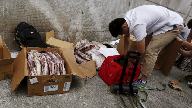 Unpacking boxes of frozen beef ribs from the US before they are smuggled across the border from Hong Kong into China. 