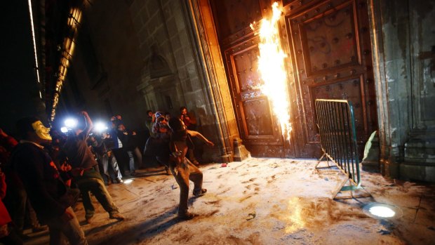 Rage boils over: A group of protesters set fire to the wooden door of the ceremonial palace.