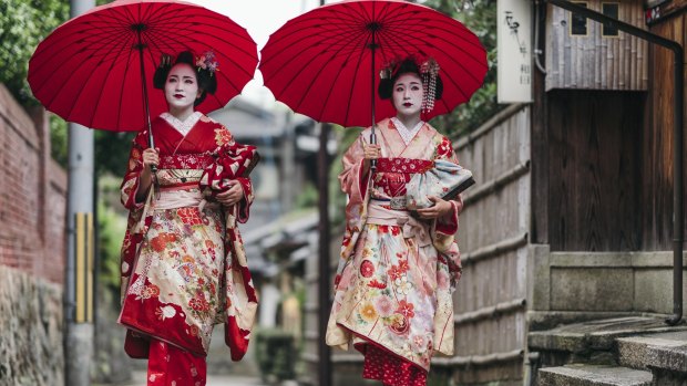 Maiko geisha walking on a street of Gion in Kyoto.