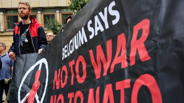 Activists march with a banner during an anti-NATO protest joined by hundreds in Warsaw, Poland, on Saturday.