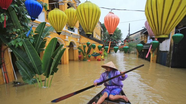 Nguyen Thi Vui paddles her boat in the flooded streets of Hoi An, Vietnam, on Monday.
