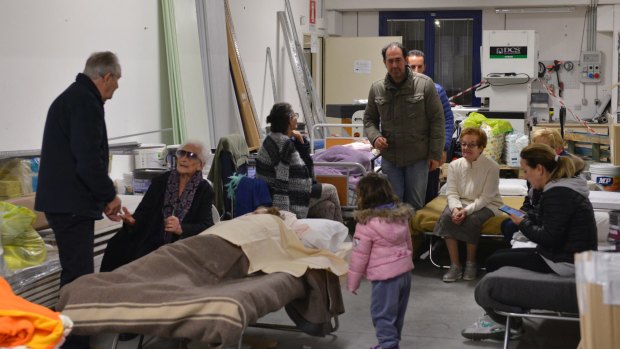 Residents prepare to spend the night in a warehouse in the village of Caldarola, Italy, on Sunday.