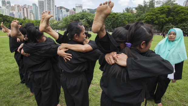 Indonesian domestic helpers practice martial arts training in Victoria Park, Hong Kong, on their day off. 