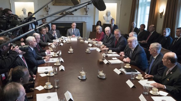 Donald Trump, centre right, with his cabinet on Monday, says it could take several years for health insurance prices to start to drop under the new plan.