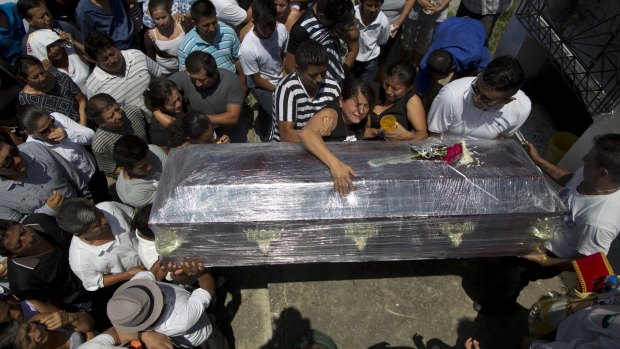 Relatives cry over the coffin of Kexly Valentino, who died with her mother Gabriela and her brother Alex in the first earthquake, in Montecristi, Ecuador.