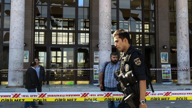 Turkish security forces and forensic police inspect the blast site after the explosions.