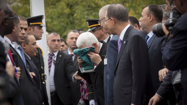 Palestine President Mahmoud Abbas kisses the flag of Palestine before it was raised at the UN for the first time on Wednesday. 

