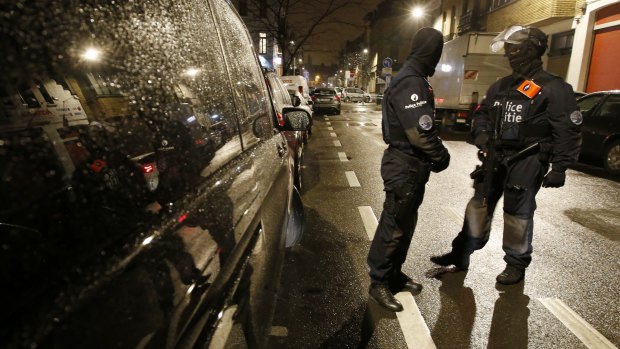 Police man a check point during a police raid in the suburb of Schaerbeek in Brussels on Thursday. 