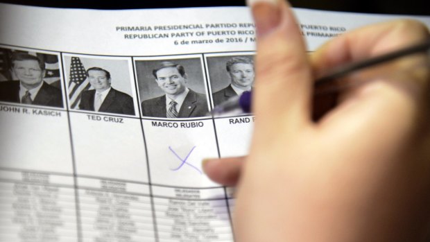 A woman marks her vote during Puerto Rico's Republican primary in San Juan, on Sunday. Puerto Rico residents cannot participate in US general presidential elections but can do so in primaries. It sends 20 delegates to the Republican convention.