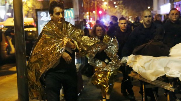 Victims of a mass shooting walk away outside the Bataclan theatre.