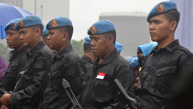 Security forces stand in the rain during the December 2 rally.