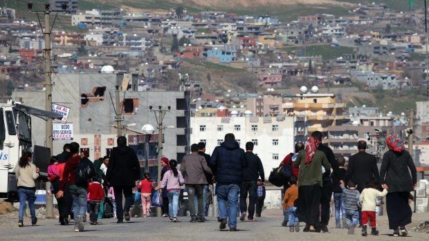 Residents walk toward the city center in Cizre after authorities relaxed the curfew.