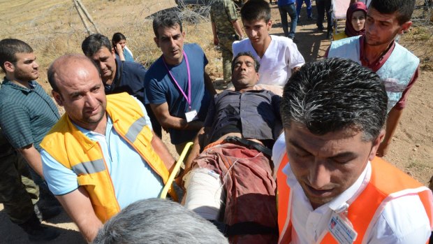 A wounded man is stretchered towards the hospital in Suruc in Turkey on Thursday after fleeing Kobane on Thursday.