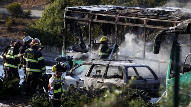 Israeli firefighters putting out the burning bus.