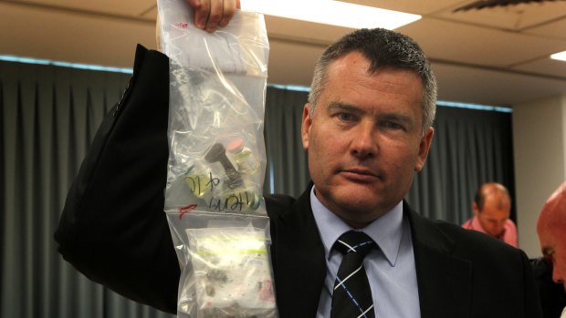 Superintendent Scott Knowles, holds up drugs that were seized during a police raid at Surfers Paradise.