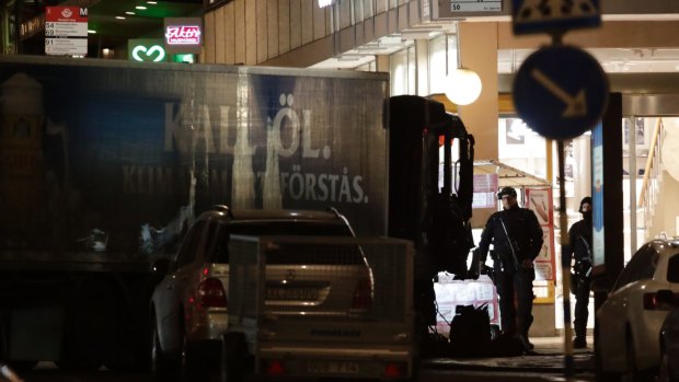 A police officer guards the scene after a truck was driven over people on a popular Swedish shopping strip.