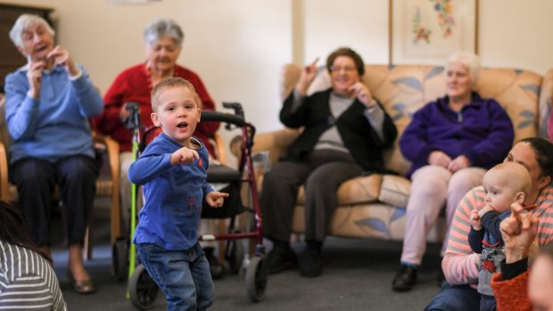 Young children and elderly residents come together to sing and dance.