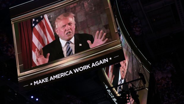 Donald Trump is seen speaking on a screen during the RNC.