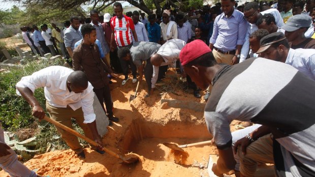 Somalis bury a victim who died in Saturday's truck blast, in Mogadishu's Medina hospital graveyard.