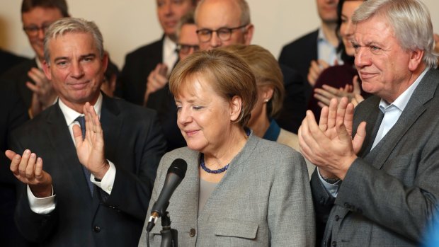 Members of the German Christian Democratic Union applaud their leader, Angela Merkel.