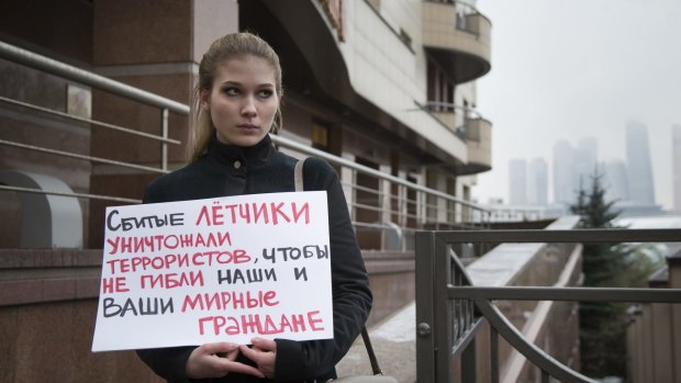 A woman holds a poster as she pickets the Turkish Embassy in Moscow following the downing of a Russian fighter on the Syrian-Turkish border. 