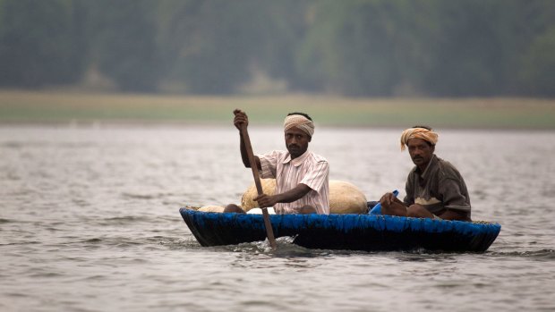 Fishermen paddle a traditional round coracle boat.