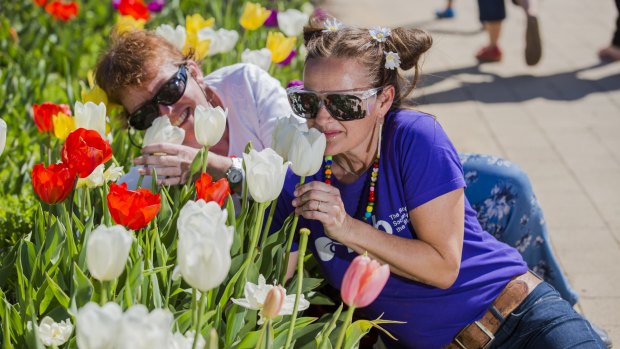 Legally blind woman Cathie Morant and Isla Smith from the Royal Society for the Blind (wearing glasses that impair her vision) enjoy the smells of Floriade.